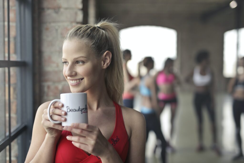 a woman in a red top holding a coffee mug.