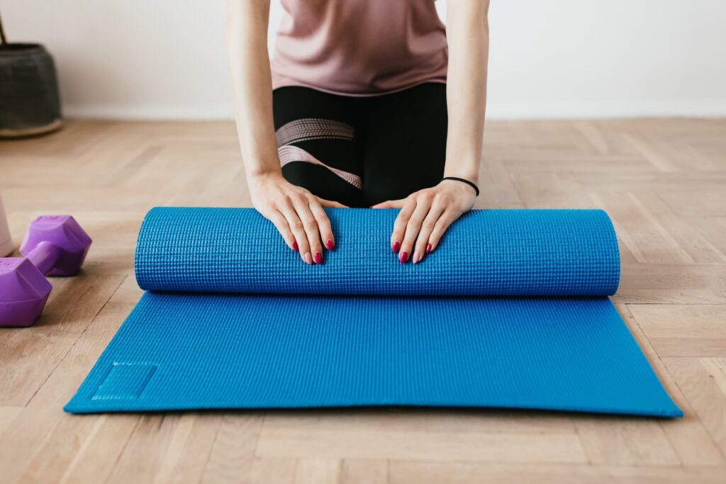 a woman is doing yoga on a blue mat.