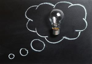 a blackboard with a light bulb and a thought bubble drawn on it.