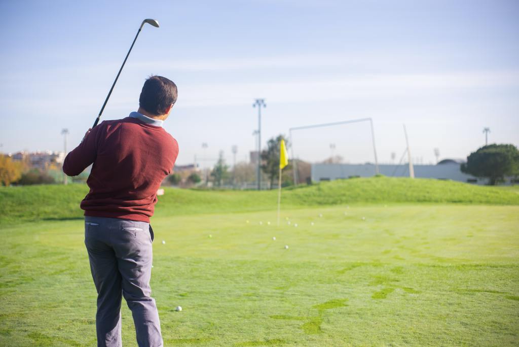 a man swinging a golf club on a golf course.