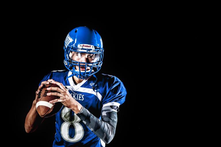 a football player in a blue uniform holding a ball.