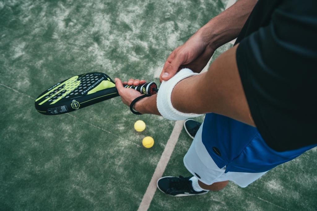a man holding a tennis racket and ball on a tennis court.