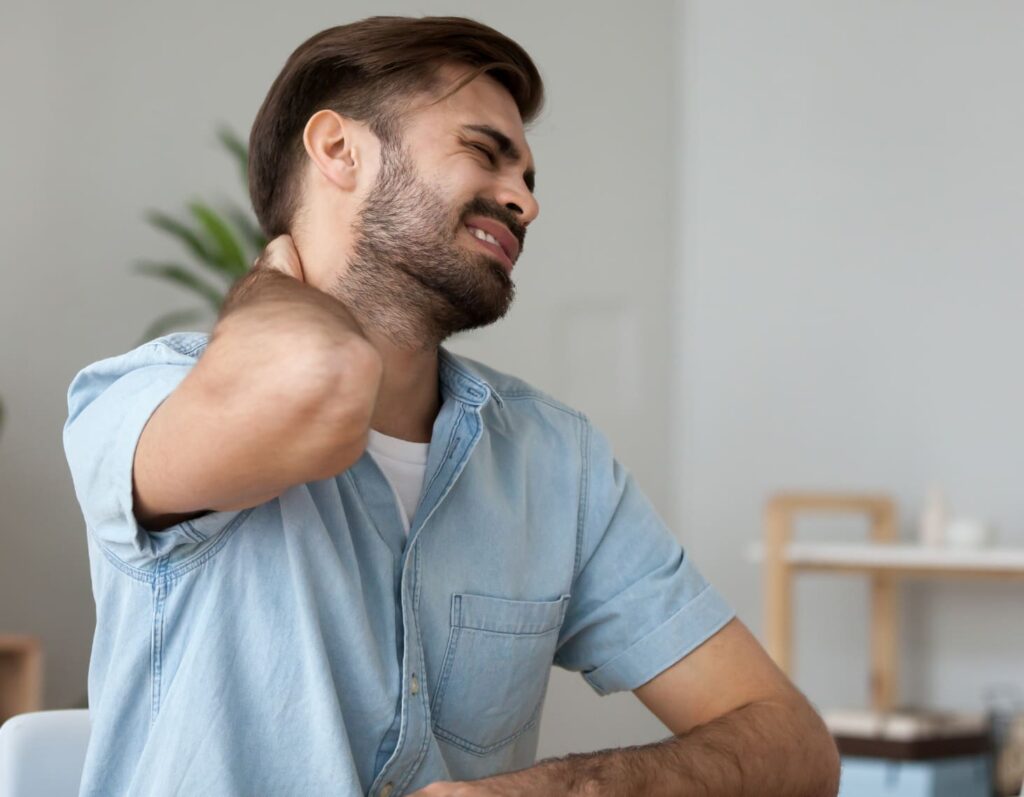 A man with a neck pain at home.