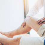 Therapist assessing a patient’s knee and lower leg range of motion during injury physical therapy.