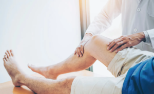 Therapist assessing a patient’s knee and lower leg range of motion during injury physical therapy.