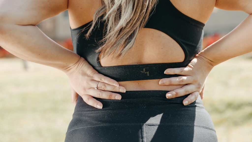 Active adult holding the front of their hip and lower abdomen to show pain, illustrating hip flexor strain recovery time and return-to-activity concerns.