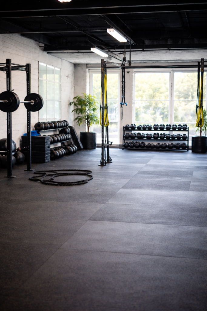 Modern strength training gym interior in Scottsdale with squat racks, dumbbells, and open workout space designed for personal training sessions
