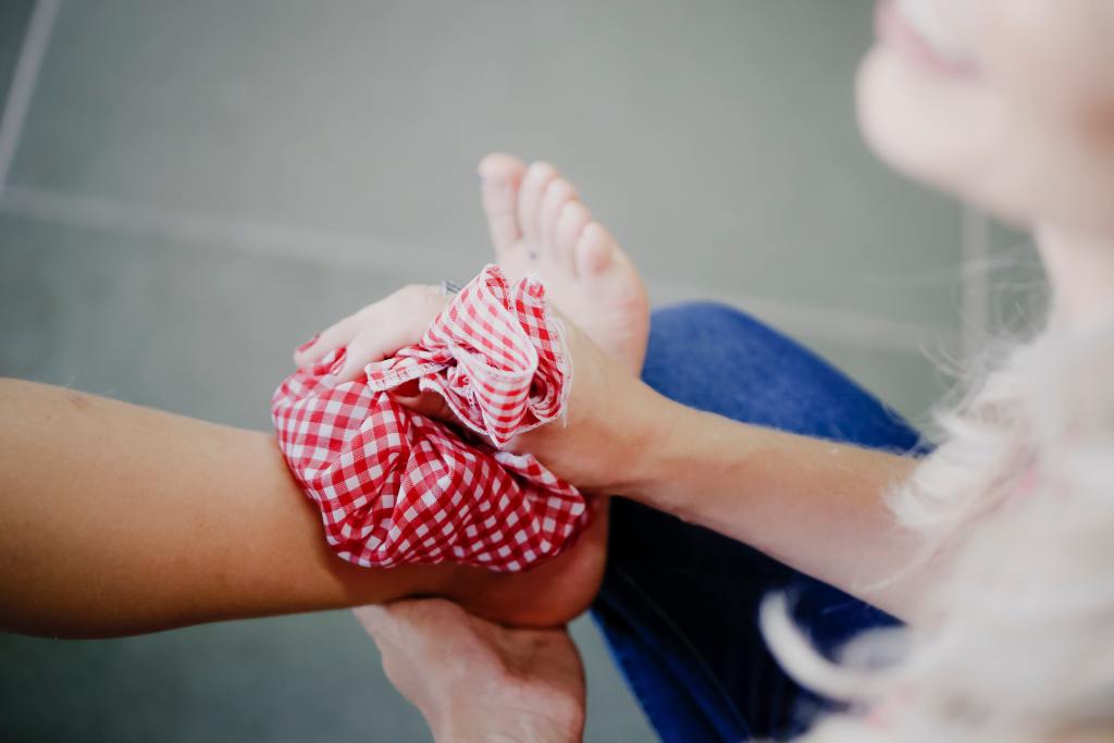 a woman with a red and white checkered bow on her arm.